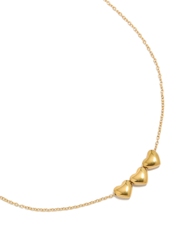 Showcasing a waterproof chunky heart trio necklace crafted from gold plated stainless steel with charm detailing close up view