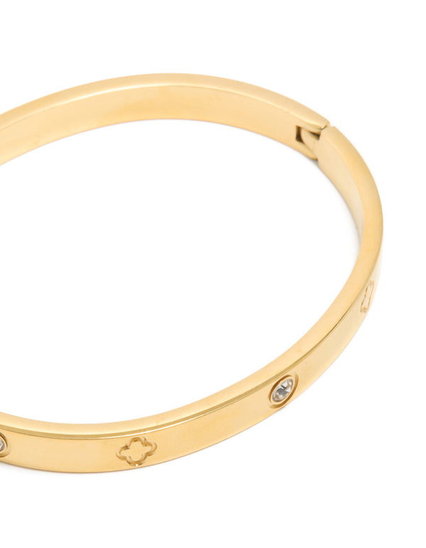 Featuring floral engravings and cubic zirconia accents, this waterproof gold plated stainless steel bangle highlights intricate detailing close up view