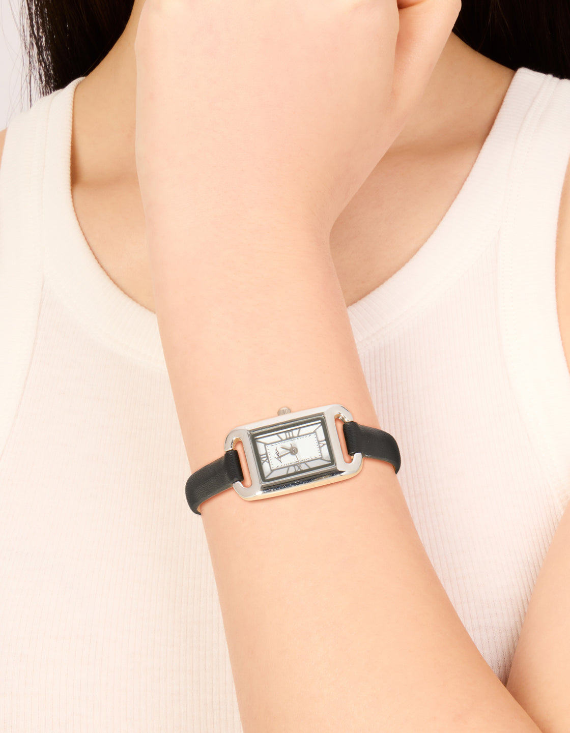 Showcasing a women's mini loop watch with roman featuring white dial, rectangle shape, analog display, casual style, PU leather strap in black and silver color on wrist view