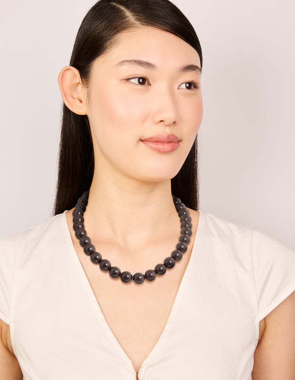 Crafted from chocolate brown acrylic with beaded and gold accents on model view