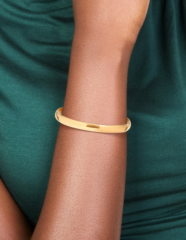Featuring a waterproof rose gold plated stainless steel round wrist cuff in gold on wrist view