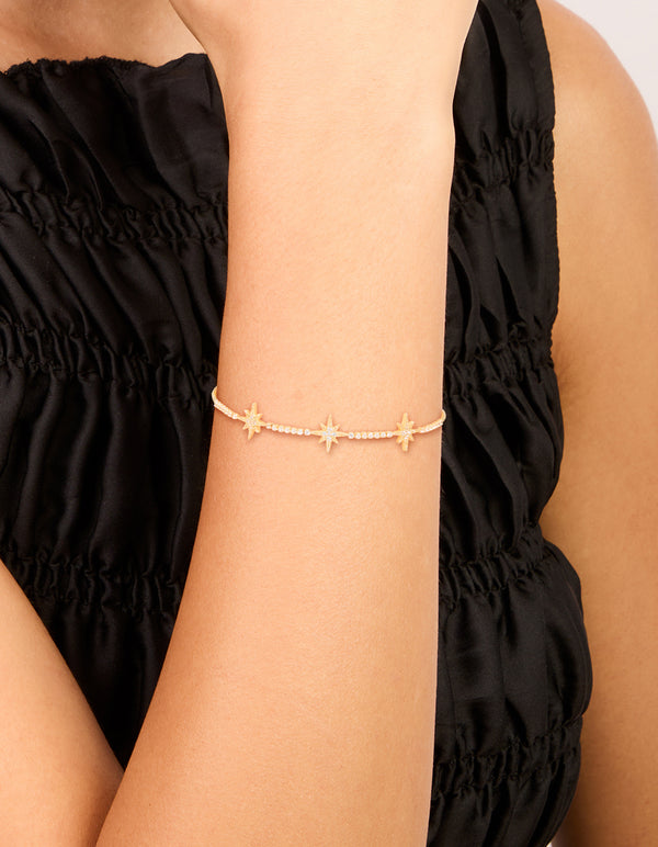 Elegant gold plated cubic zirconia stars toggle bracelet featuring celestial design on wrist view
