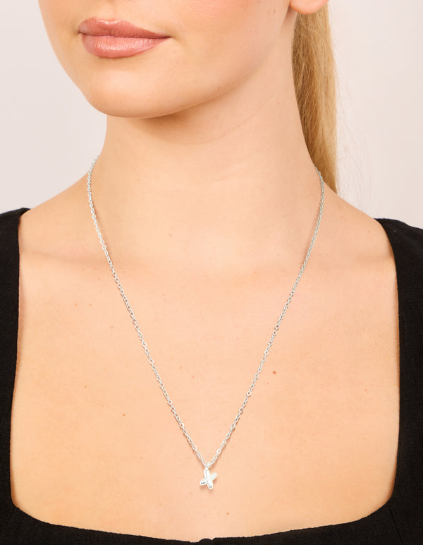 Featuring a waterproof stainless steel mini bubble letter X necklace with initial pendant in silver on neck view