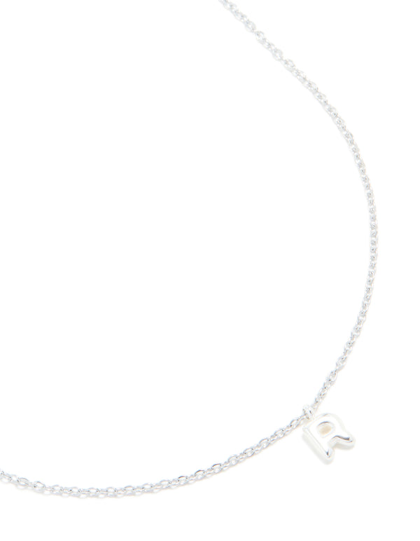 Showcasing a waterproof stainless steel mini bubble letter R necklace featuring initial with pendant in silver and dainty styling close up view