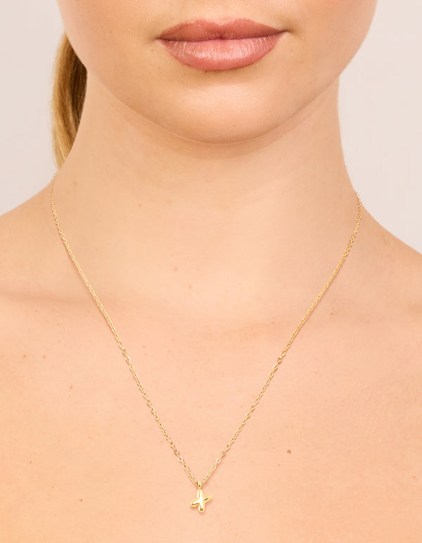 Featuring a waterproof bubble letter X necklace in gold plated stainless steel with initial pendant on neck view