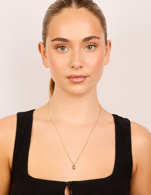 Featuring a waterproof gold plated stainless steel mini bubble letter Q initial pendant necklace on model view