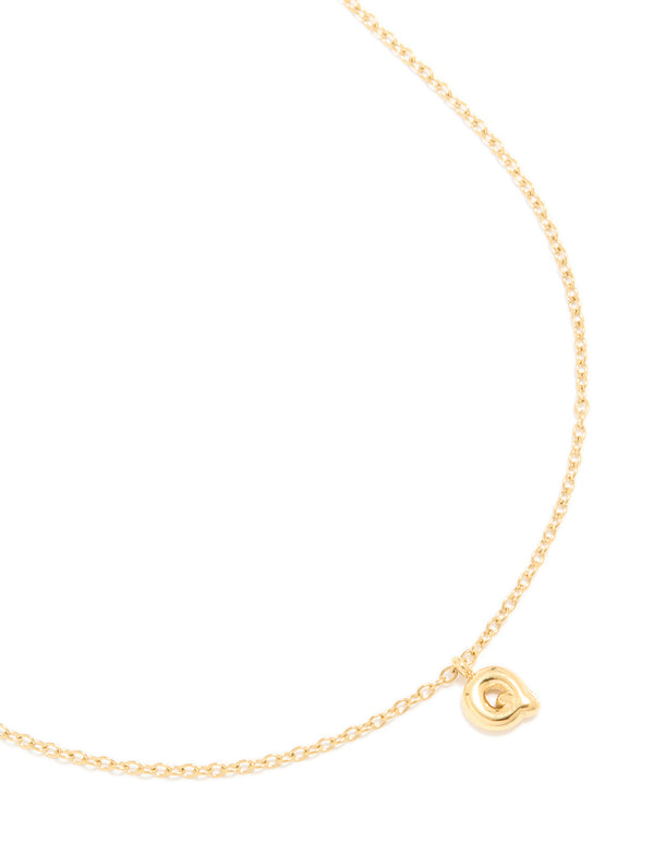 Showcasing a waterproof gold plated stainless steel mini bubble letter Q initial pendant necklace close up view