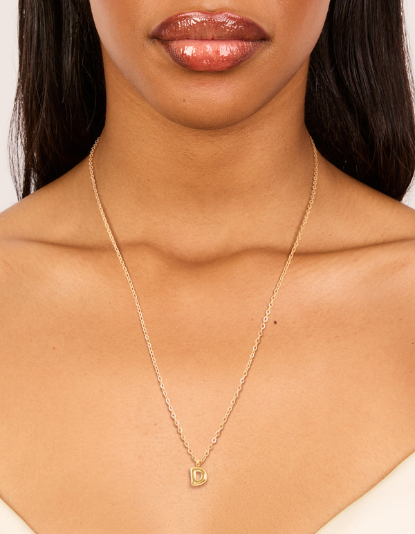 Crafted from waterproof gold plated stainless steel, this mini bubble letter D initial pendant necklace with dainty style on neck view