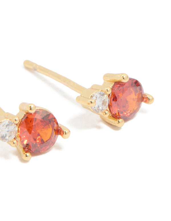 Featuring waterproof stainless steel dainty stud earrings in coral and clear cubic zirconia stones in gold plated finish post detail view