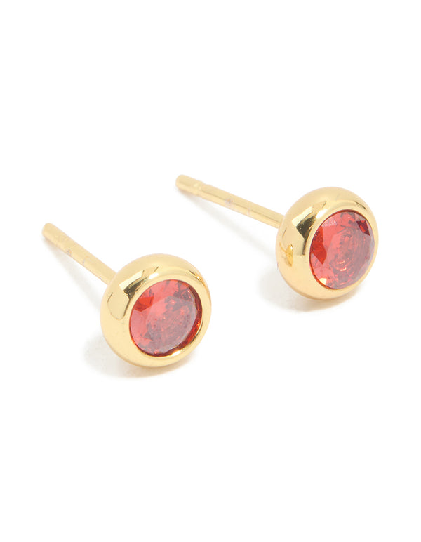 Featuring waterproof stainless steel cubic zirconia January birthstone bezel set stud earrings with round stone cut in gold and crimson front view