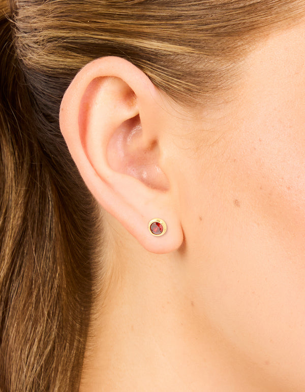 Discover waterproof gold plated stainless steel bezel set stud earrings with cubic zirconia in crimson on ear view