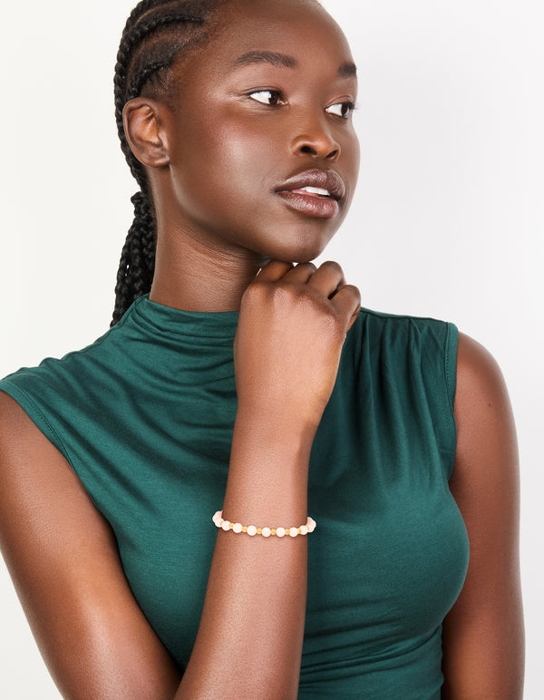 Crafted from waterproof gold plated stainless steel with rose quartz beaded stretch bracelet on model view