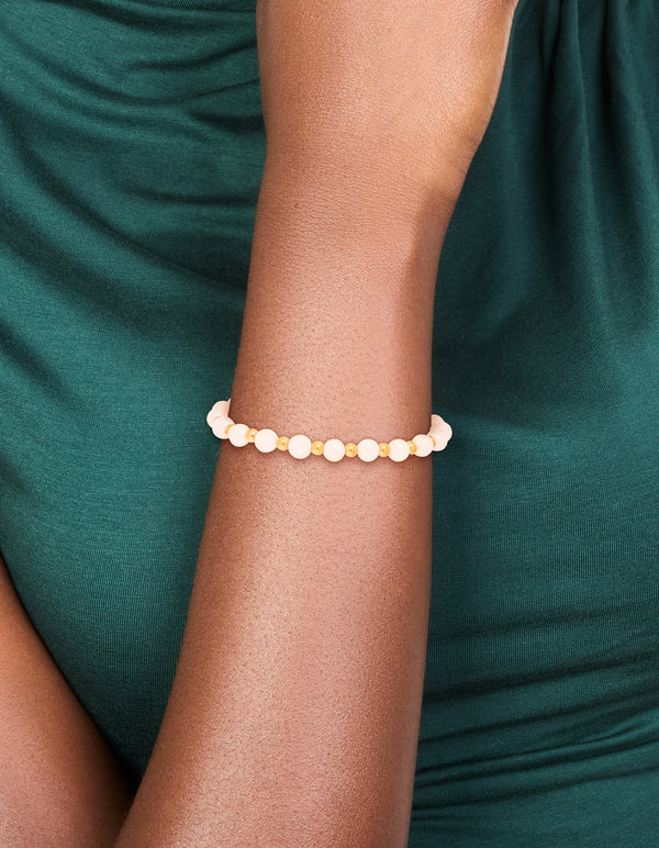 Showcasing a waterproof gold plated stainless steel rose quartz beaded stretch bracelet on wrist view