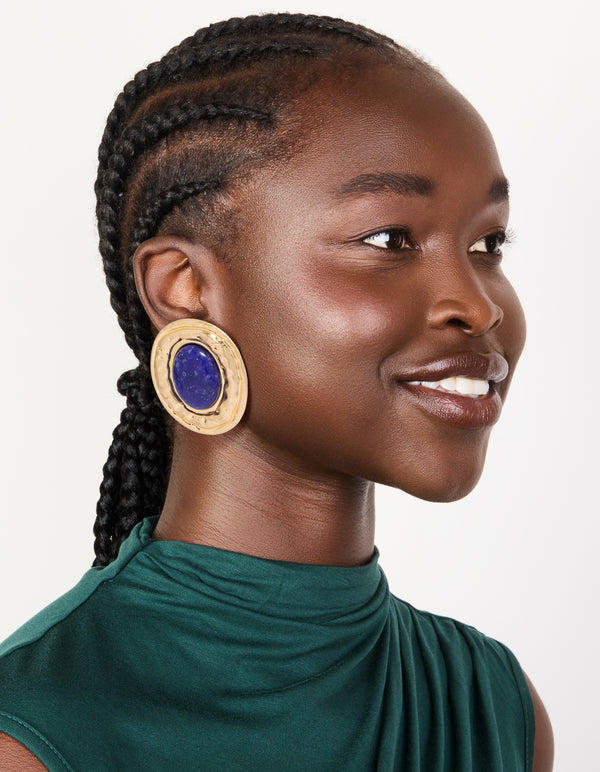 Crafted from worn gold with round hammered dark blue acrylic stud earrings in statement style on model view