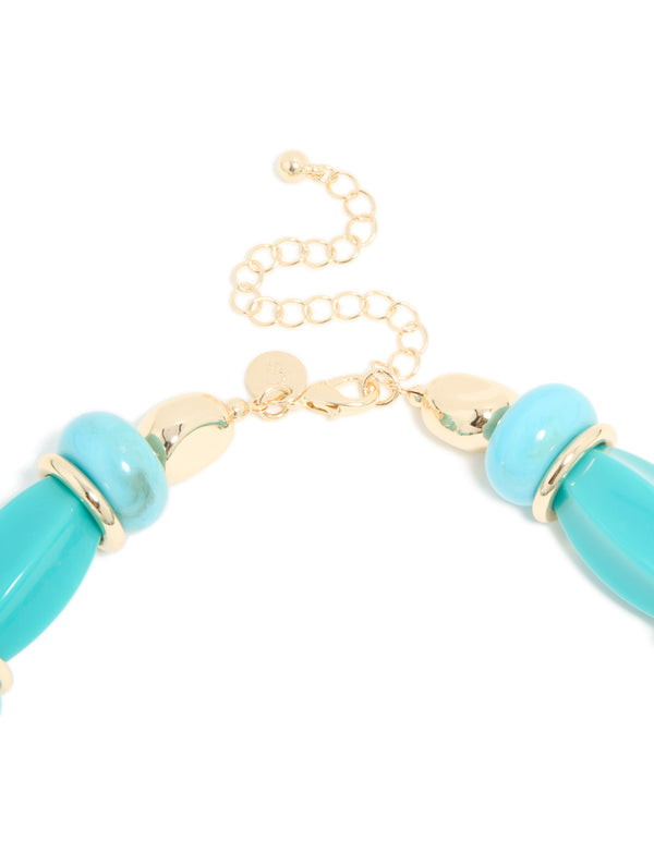 This aqua acrylic beaded necklace highlights the adjustable clasp detail view with gold chain and round turquoise elements