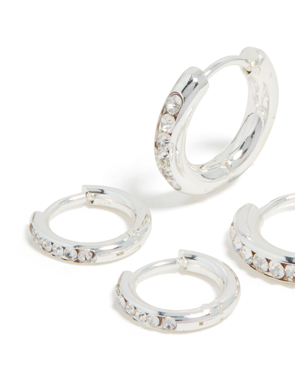 Highlighting the waterproof stainless steel and cubic zirconia construction of these huggie earrings in silver, 2-pack close up view