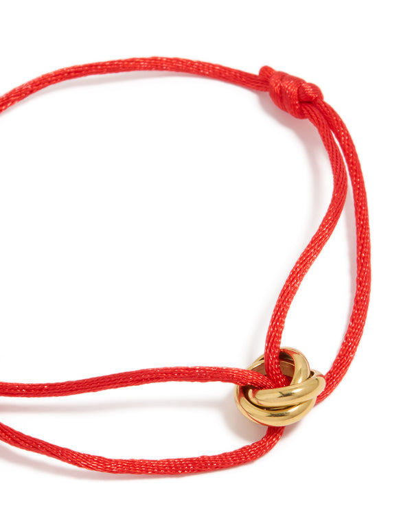 Featuring a waterproof adjustable bracelet with gold plated stainless steel and red cord close up view