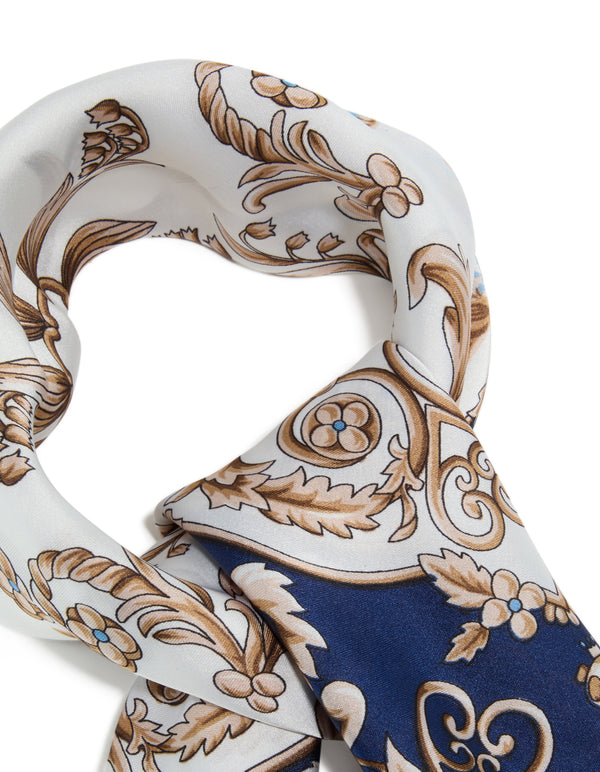 Crafted from polyester, this dark blue and white baroque flower fabric scarf features intricate leaf and floral patterns in navy, tan, and gold detail view