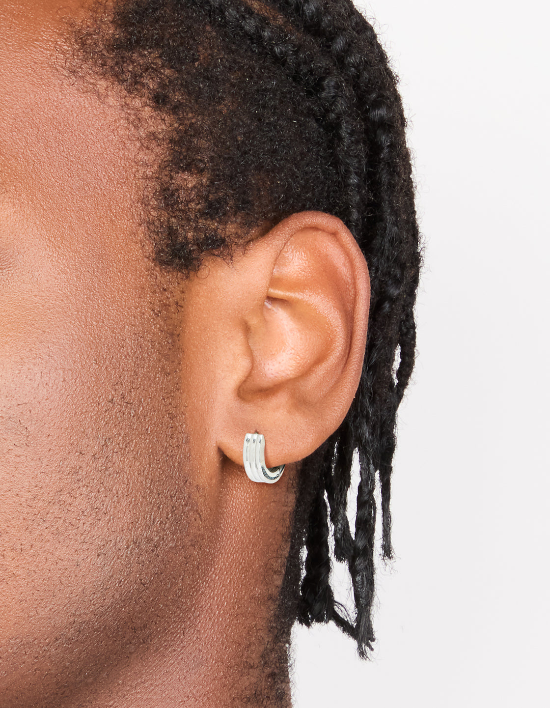 Showcasing mens waterproof ribbed huggie earrings crafted from stainless steel in silver on ear view