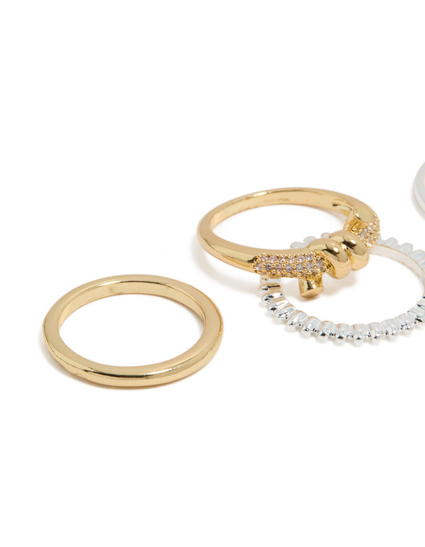 Featuring mixed metal plated cubic zirconia knotted textured rings 4-pack with beads and charm in gold, silver, clear and pink stone close up view