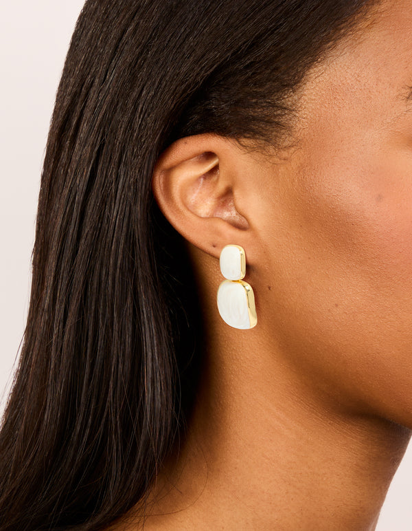 Showcase these statement drop earrings in ivory with cream enamel and gold plated accents on ear view