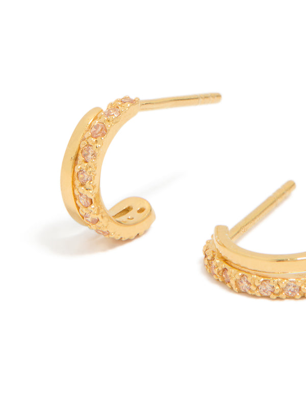 Highlighting gold plated sterling silver cubic zirconia double hoop huggie earrings with pink accents close up view