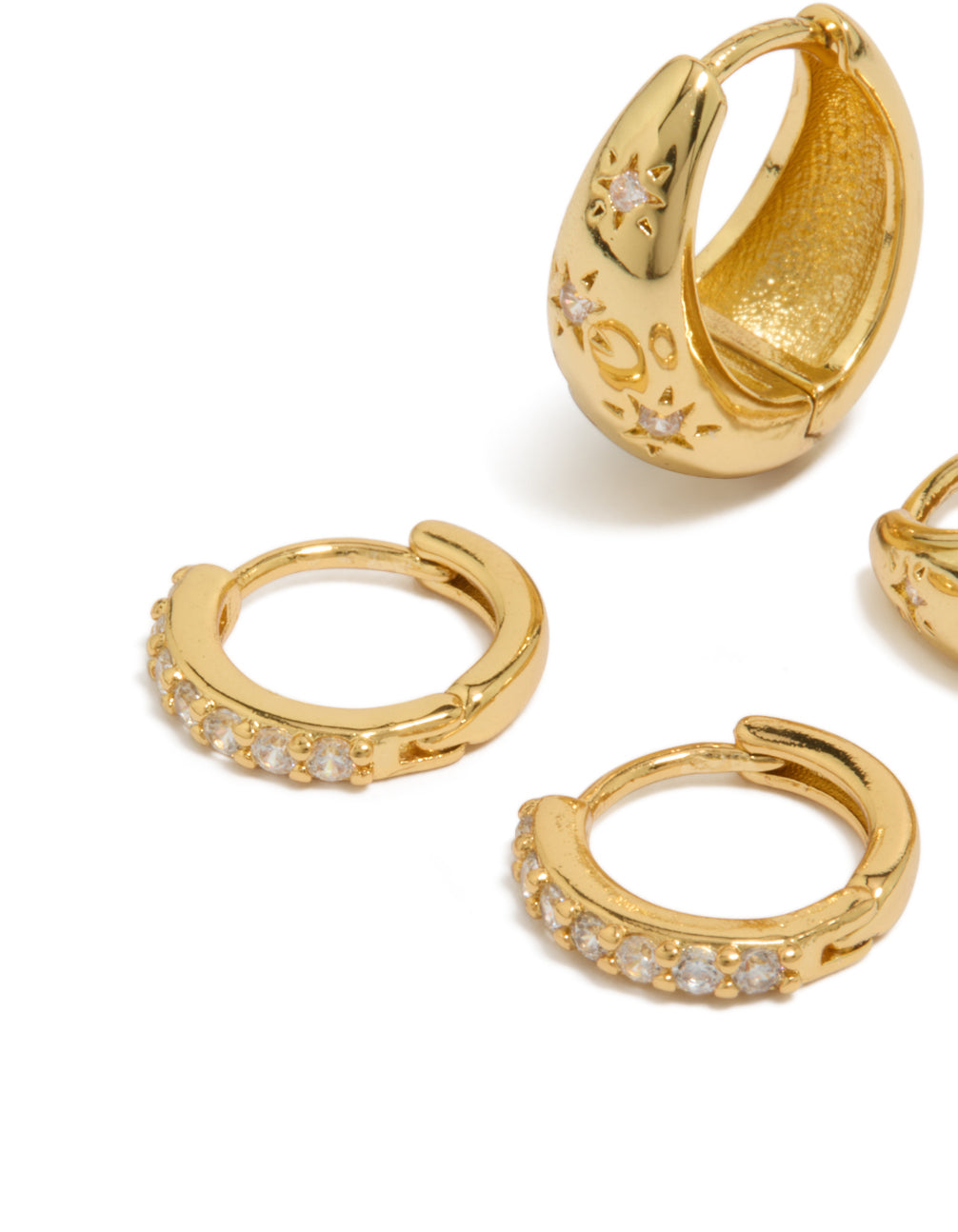 Displaying statement celestial star and crystal cubic zirconia huggie earrings in a 2-pack, crafted from gold plated brass close up view