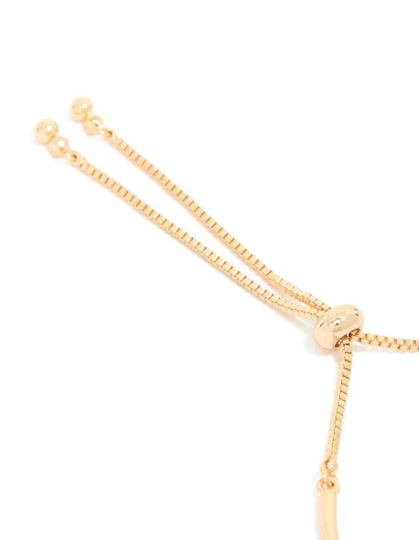 Showcasing gold cubic zirconia bow charm toggle bracelet closure detail view
