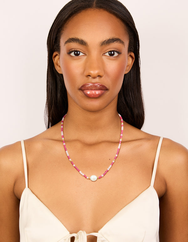 Featuring a waterproof beaded necklace with pearl crafted from gold plated stainless steel in pink on model view