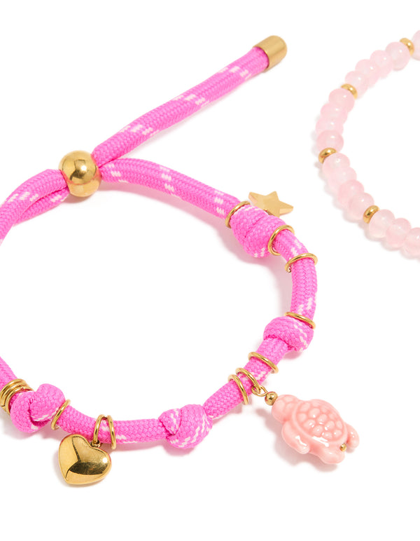 Displaying waterproof gold plated stainless steel semi precious stone and sea cord bracelets in a 2-pack with beads, heart and ocean charm, rose quartz accents close up view
