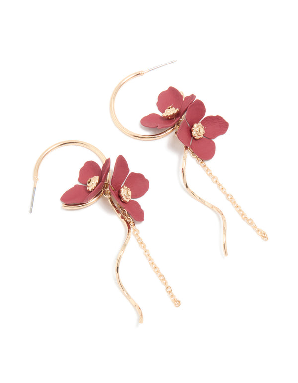 Showcasing statement drop earrings with floral accents in gold and red front view