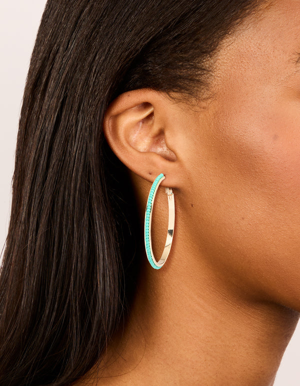 Showcasing large thin hoop earrings with aqua beads in turquoise and gold on ear view