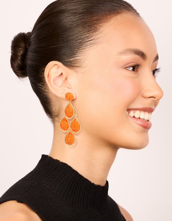 Featuring orange paper teardrop earrings with statement design and gold finish on model view