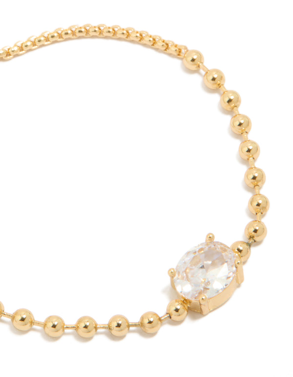 Showcasing gold ball and cubic zirconia oval toggle chain bracelet with gold plated finish close up view