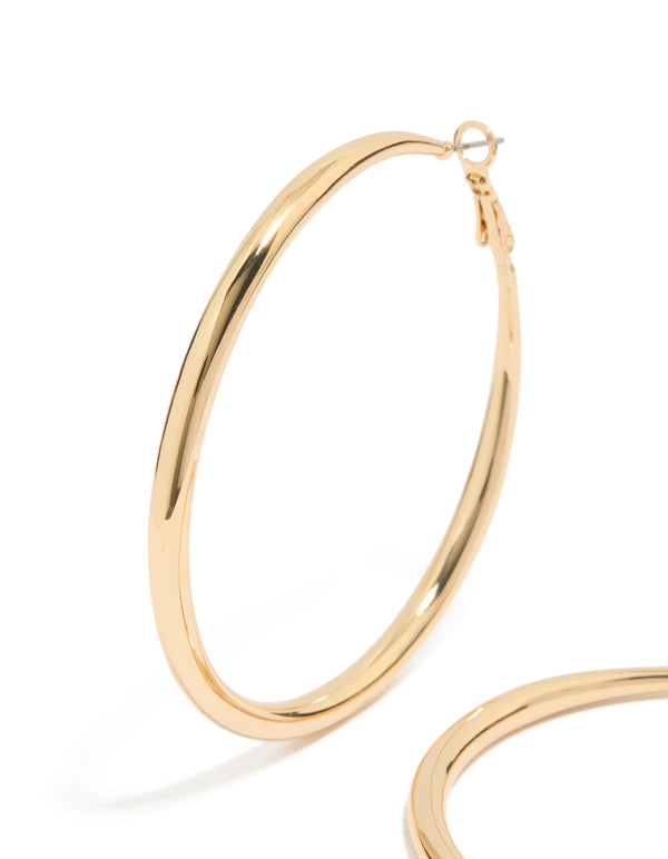 Featuring large hoop earrings in gold plated material with hoop closure close up view