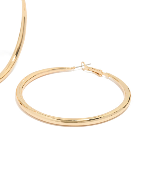 Highlighting large hoop earrings crafted from gold plated material with hoop closure post detail view