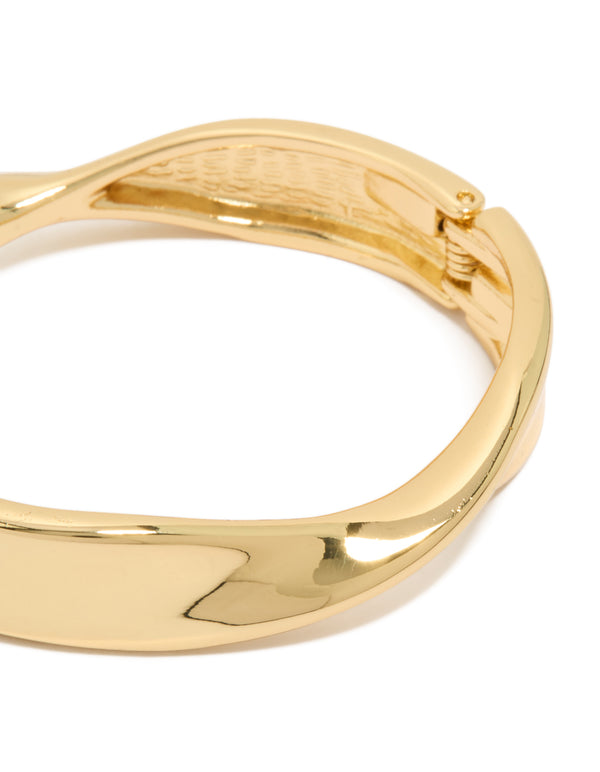 Showcasing a twisted thick gold plated statement chunky bangle with secure closure detail view