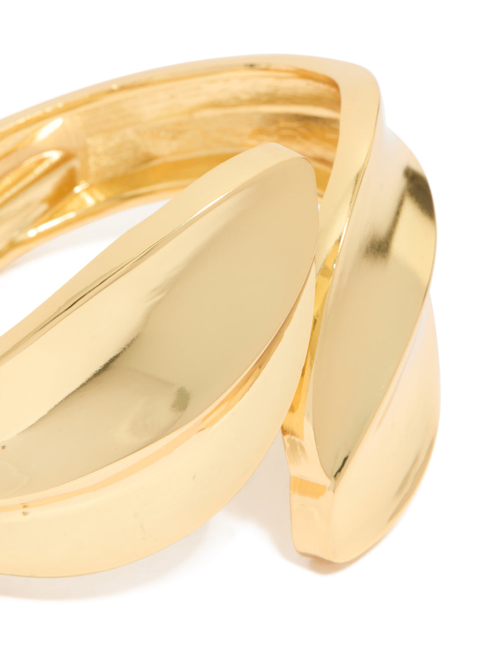 Crafted with gold plated metal thick curved statement bangle close up view