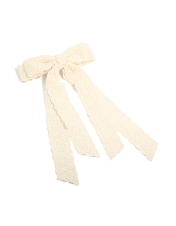 Discover a charming bow clip with floral lace fabric in ivory front view