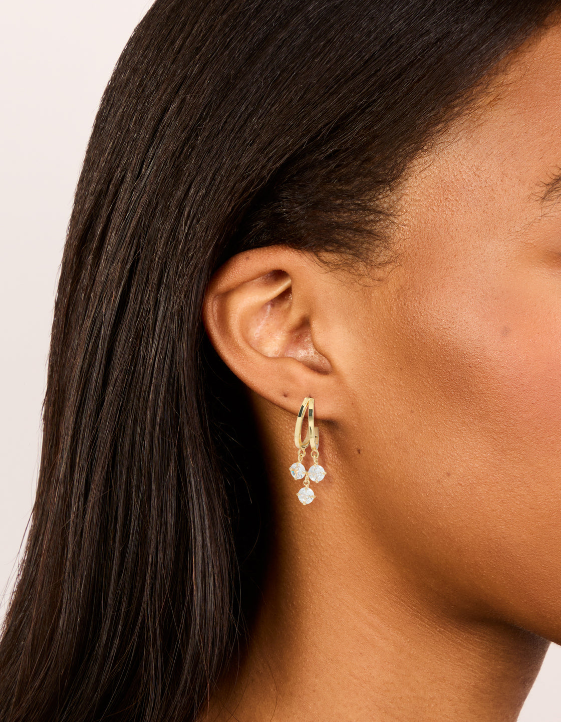 Crafted from gold plated cubic zirconia double drop hoop earrings with charm on ear view