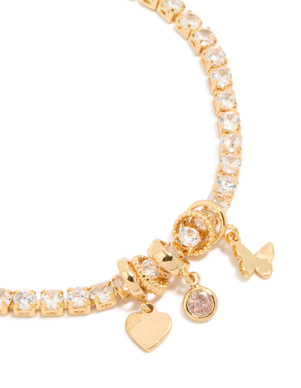 Featuring a gold plated cubic zirconia mixed charm tennis bracelet with butterfly and heart details close up view