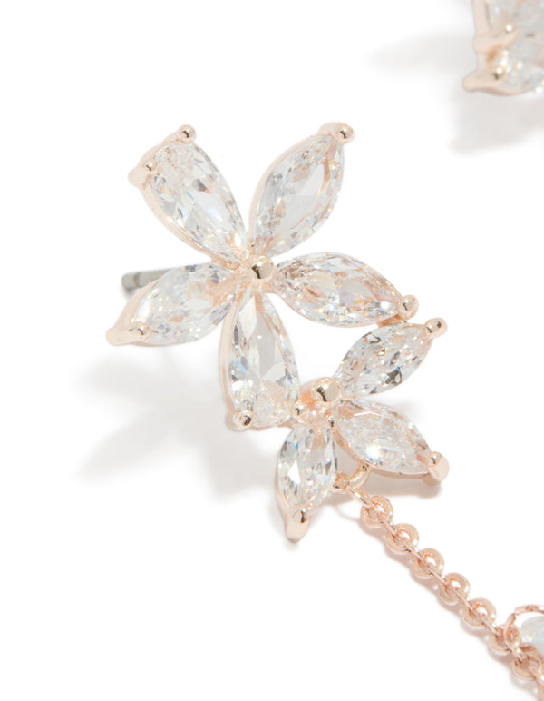 Showcasing rose gold plated cubic zirconia flower station drop earrings with beaded charm details and floral pattern close up view