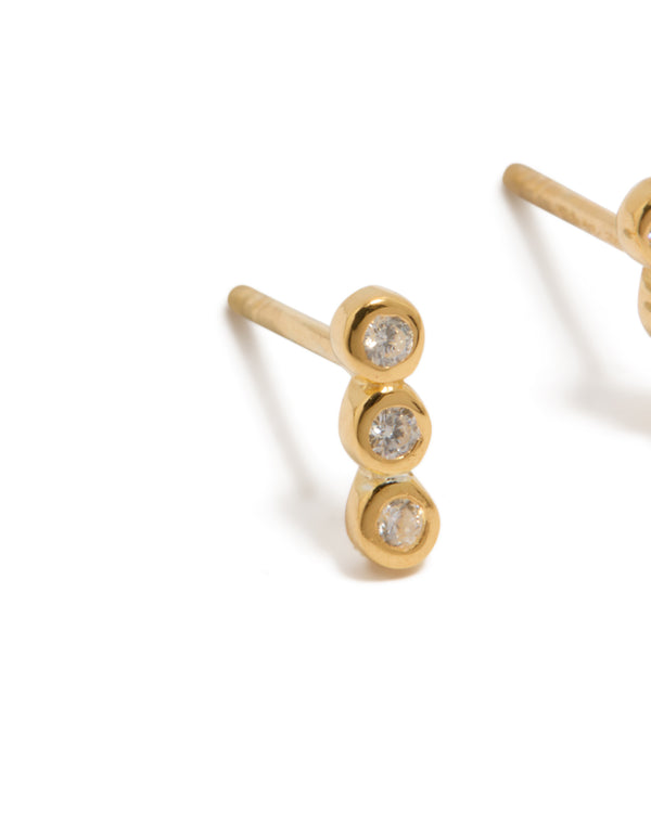 Featuring gold plated sterling silver cubic zirconia bezel trio drop stud earrings with clear accents close up view