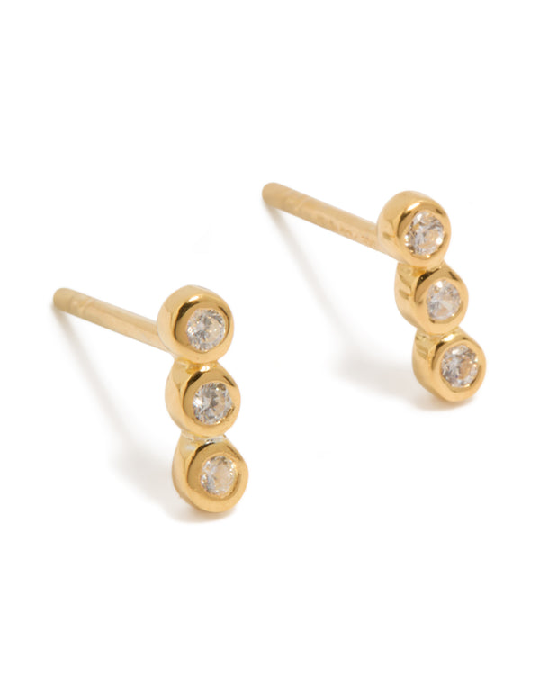 Showcasing gold plated sterling silver cubic zirconia bezel trio drop stud earrings with clear accents front view