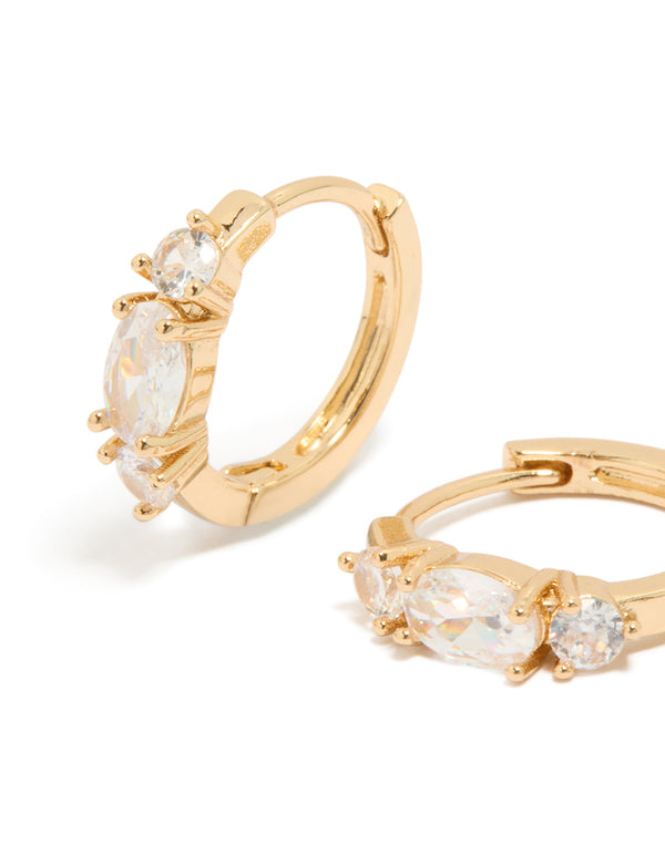 Featuring gold cubic zirconia dainty huggie earrings close up view