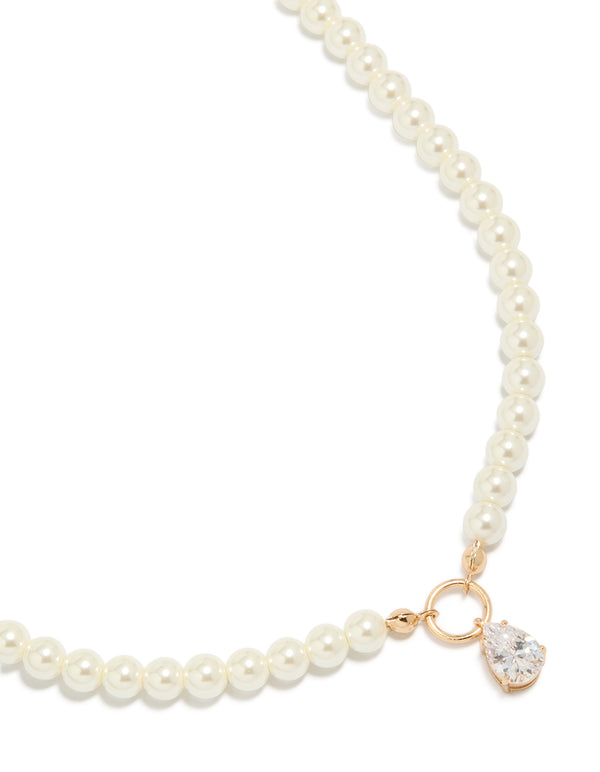 Showcasing a gold cubic zirconia dainty pearl pendant necklace in a close up view