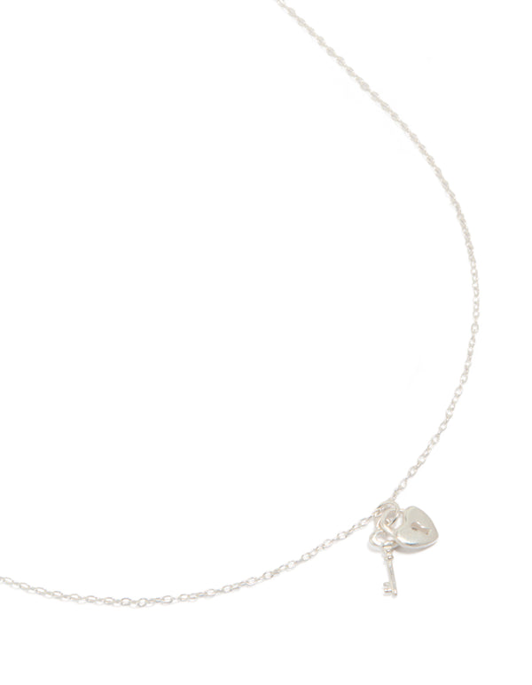 Discover a heart and key pendant necklace featuring charm detailing crafted from sterling silver in a beautiful silver color close up view