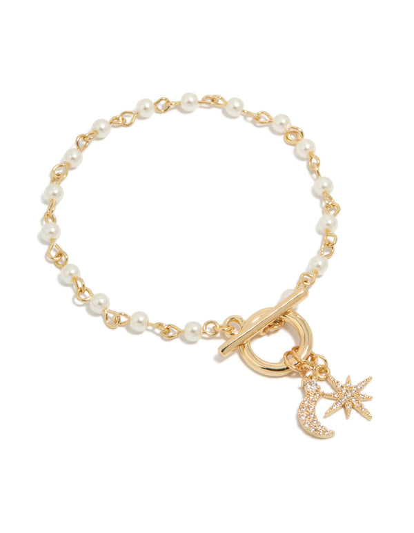 Luminous gold plated pearl and cubic zirconia bracelet featuring celestial star and moon charm with toggle closure front view