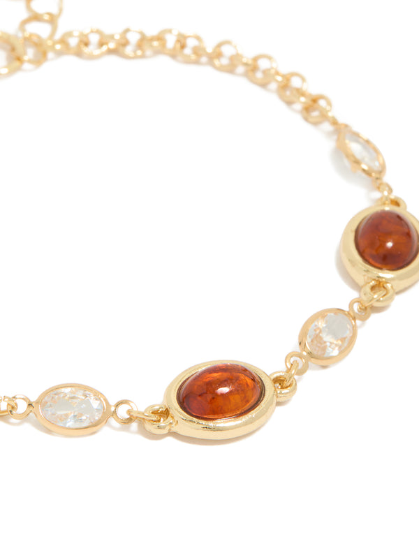 Showcasing a gold plated bracelet with cognac beads and clear cubic zirconia in a tennis style close up view