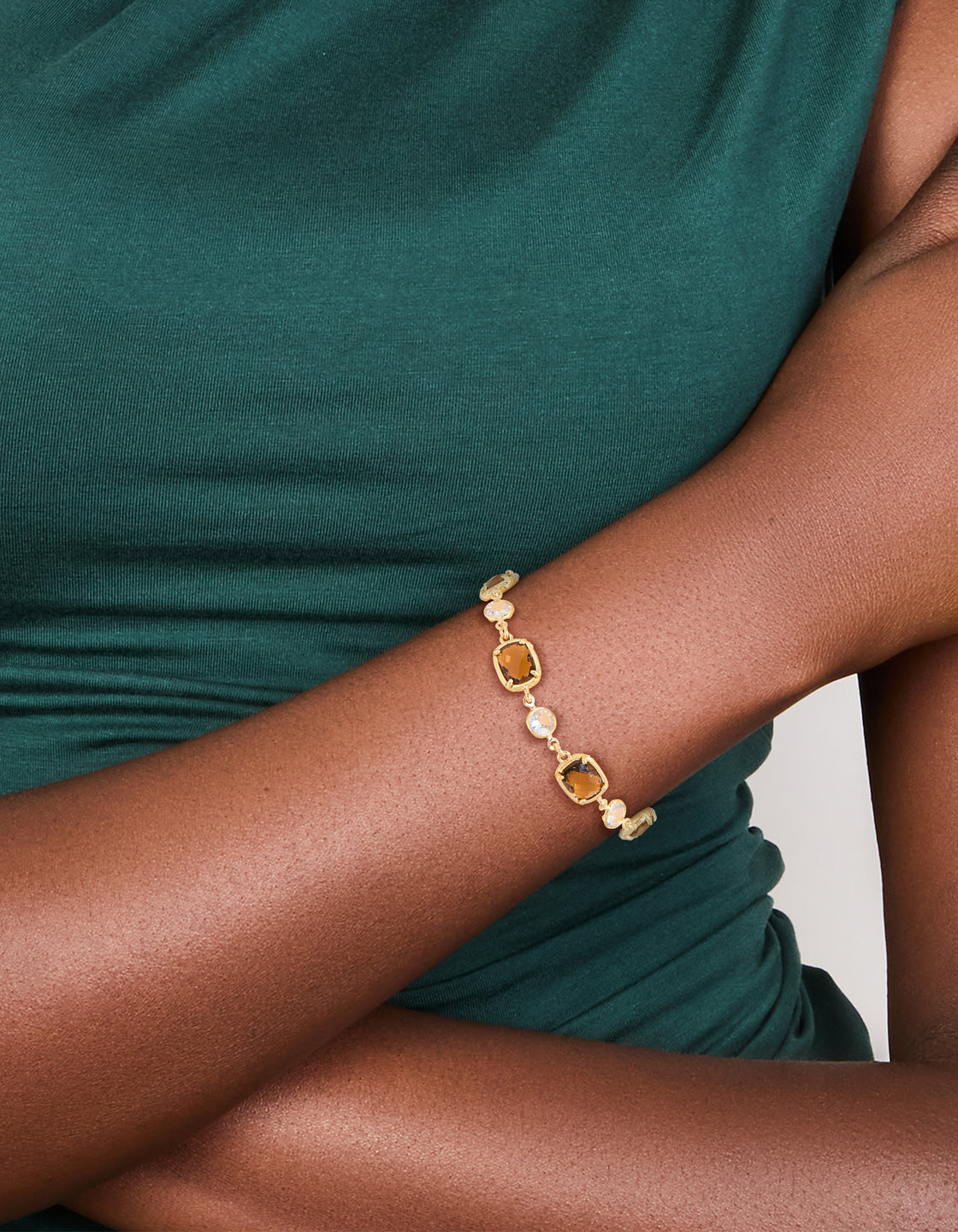 Elegant gold plated clear and cognac cubic zirconia square cut bezel toggle bracelet on wrist view